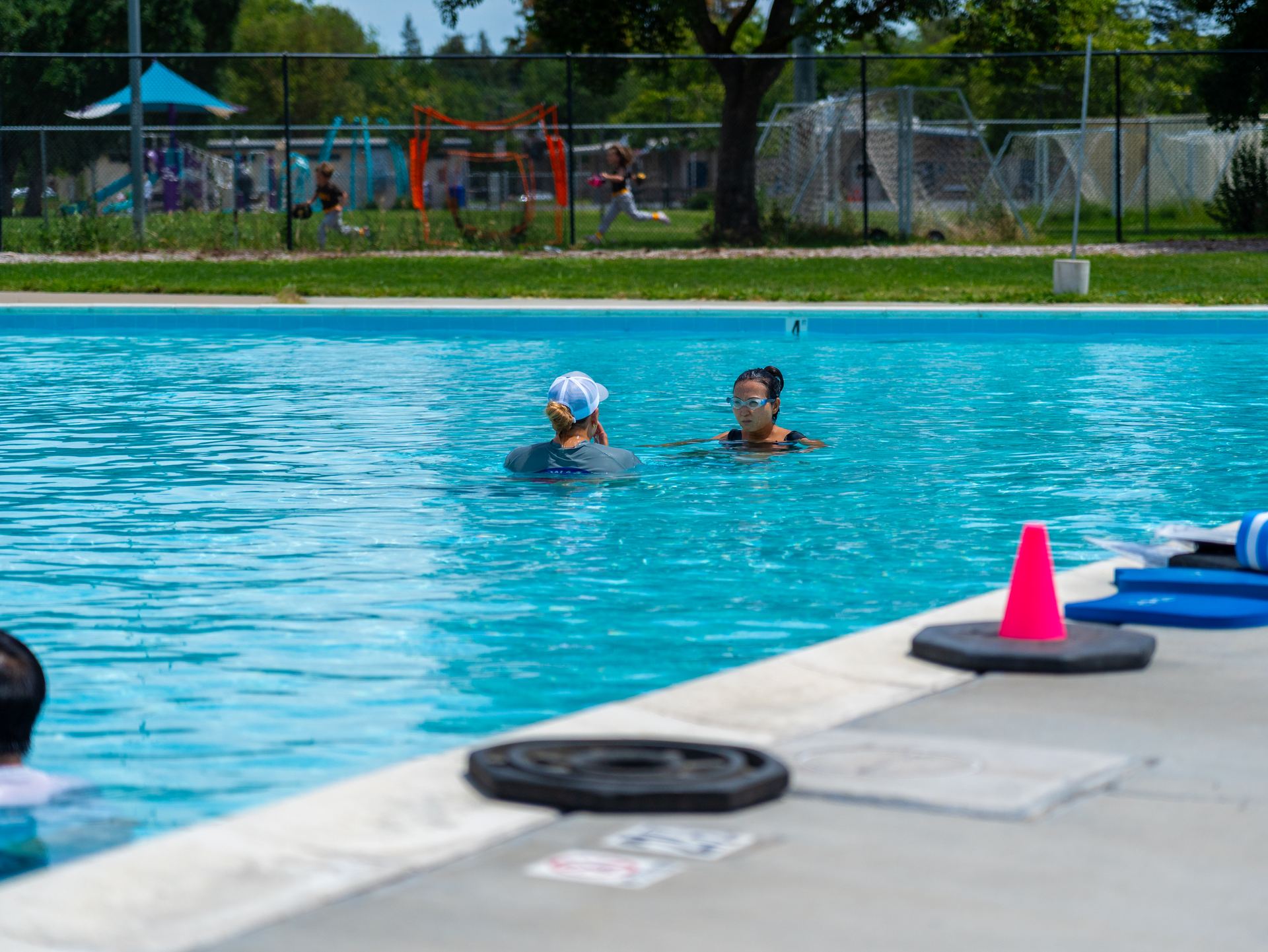 A SWAG instructor talking with a participant in the pool